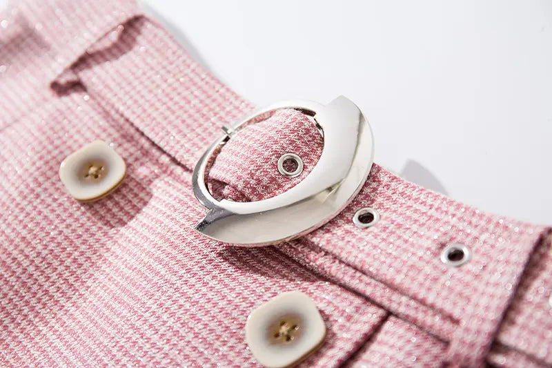 Pink houndstooth fabric belt with silver buckle for stylish women’s pleated mesh skirt.