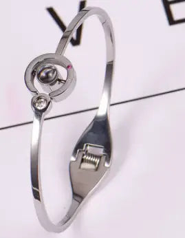 Silver-toned bangle bracelet with circular accent in a stylish four-leaf clover design