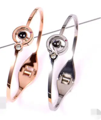 Two elegant metal projection bracelets featuring a four-leaf clover design in gold and rose gold.