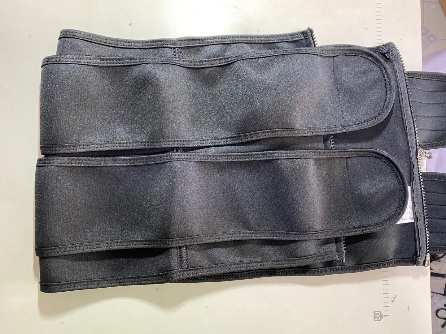 Black back support belt featured in The Sports Tuck Belts with adjustable buckle rows.