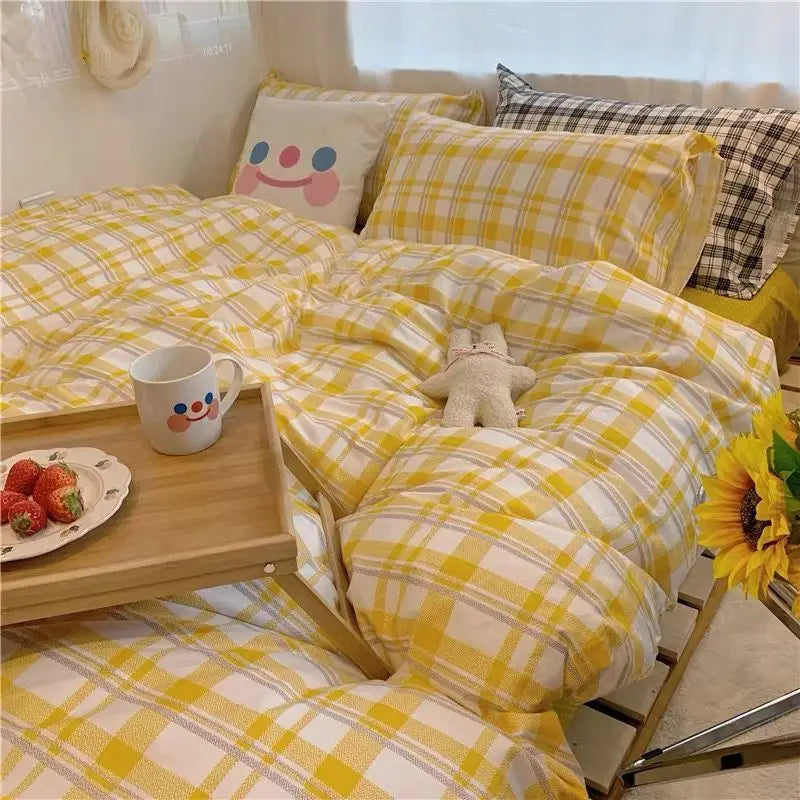 Three-piece set of single bed sheets featuring yellow and white plaid bedding design.