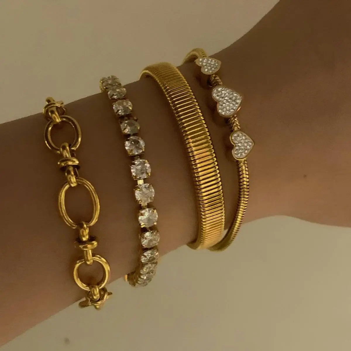 Gold bracelets adorned on a wrist showcasing a stylish jewelry set for women.