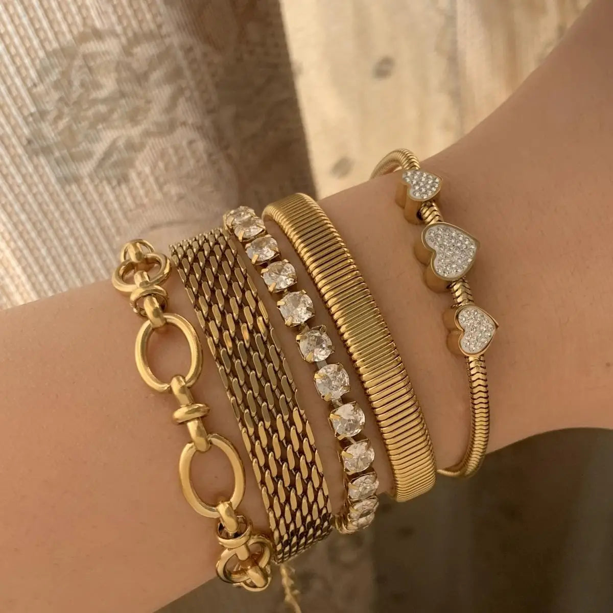 Gold bracelets elegantly adorned on a wrist, showcasing stylish geometric designs.