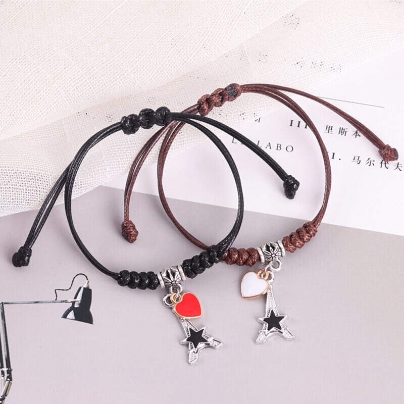 Two braided friendship bracelets with Eiffel Tower charms for couples.