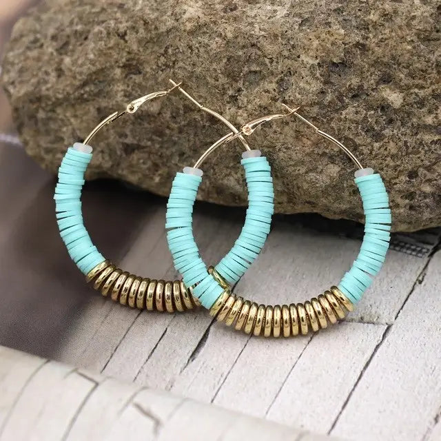Hoop earrings featuring turquoise and gold beads in a stylish silver design.