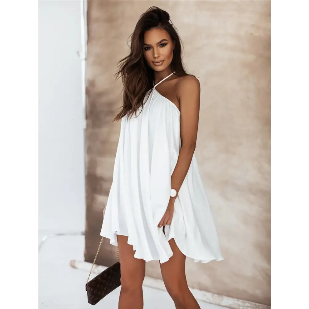 Flowy white halter-neck mini dress with asymmetrical hemline for summer fashion.